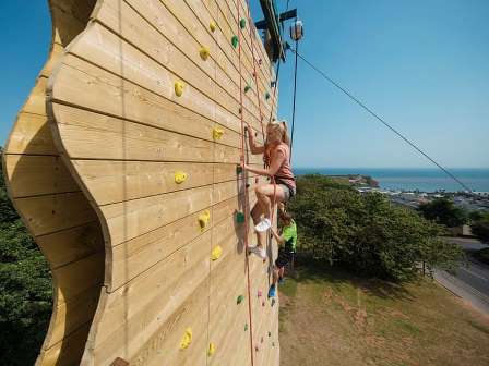 Woman on climbing wall at Haven Devon Cliffs Holiday Park