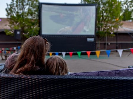 Mother and child watching outdoor cinema at Sandy Balls