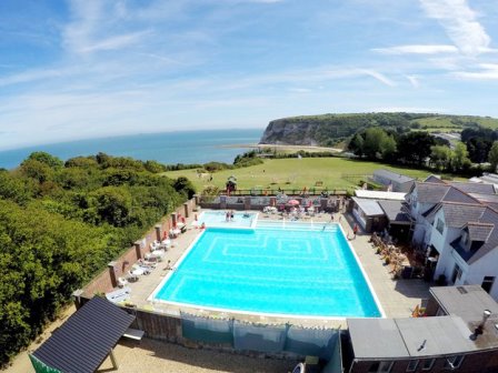 Outdoor swimming pool and beach at Whitecliff Bay holiday park