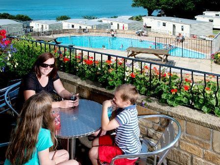 Family overlooking outdoor swimming pool at Sandaway Beach Holiday Park