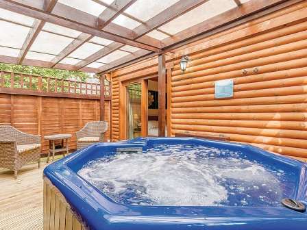 Hot tub next to lodge at Tilford Woods Lodge Retreat